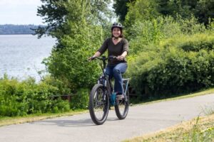 Woman riding e-bike near a lake.